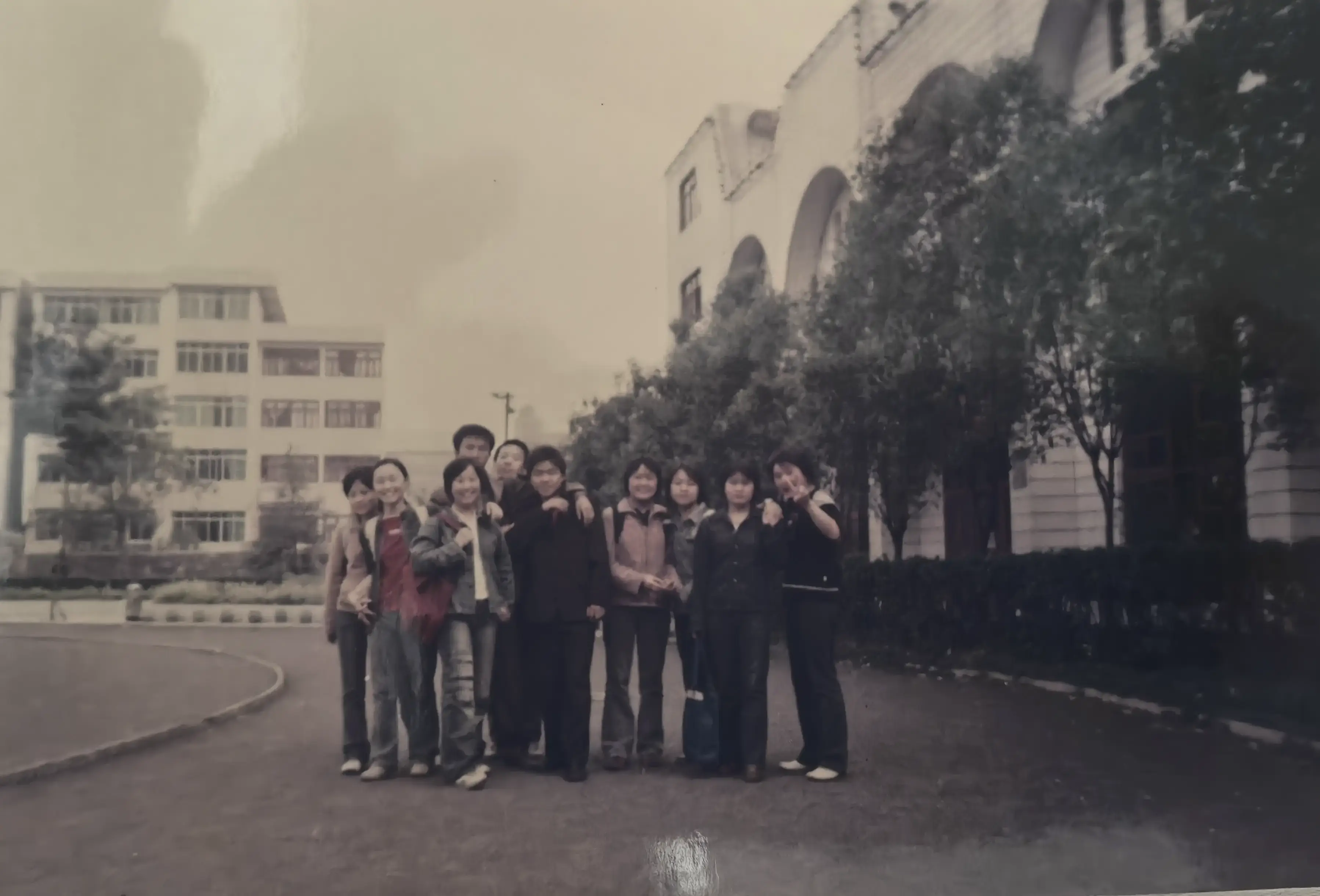 2006年操场落日余晖中的剪影，212班同学们在跑道上的背影合影。逆光中少年们的轮廓与远处教学楼融为一体，这张充满艺术感的照片，恰如我们无法复刻却永远怀念的黄金时代。